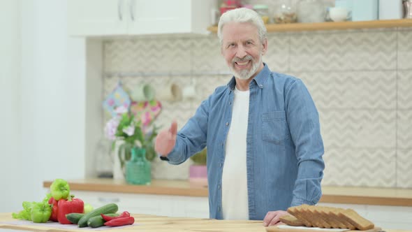 Old Man Showing Thumbs Up While Standing in Kitchen alt