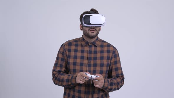 Young Bearded Indian Hipster Man Playing Games and Using Virtual Reality Headset alt