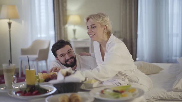 Happy Caucasian Bride and Groom Enjoying Honeymoon in Luxurious Hotel alt