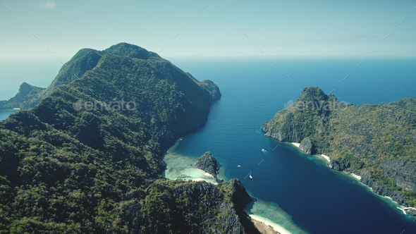Mountainous greenery islets at sea bay coast aerial view. Amazing seascape of green tropical forest