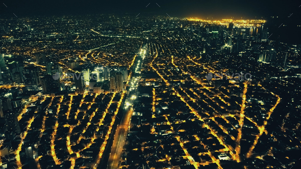 Aerial slow motion cityscape at night. Illuminated streets of Manila downtown at traffic city route