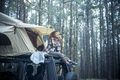Happy free beautiful people caucasian woman sit down on the roof of the car with tent mounted - PhotoDune Item for Sale