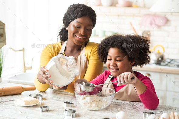 Joyful little african american girl making cookies for her family Stock  Photo by Prostock-studio