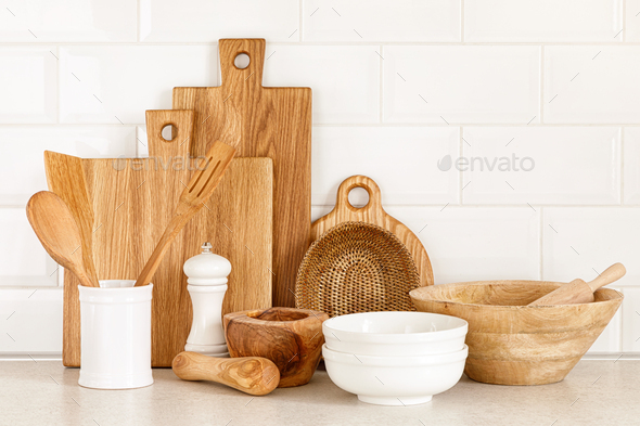 White ceramic utensils and kitchen utensils on a wooden countertop