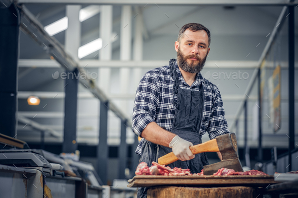 Bearded butcher cut fresh meat. Stock Photo by fxquadro | PhotoDune