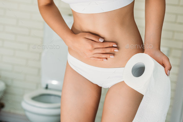 partial view of girl in white underwear holding toilet paper while
