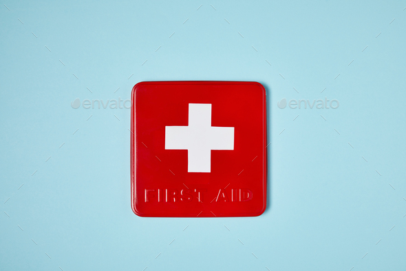 top view of red first aid kit box on blue surface