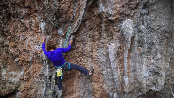 Slow Motion Back View Female Rock Climber Climbs on Overhanging Limestone Cliff By Tough Route alt
