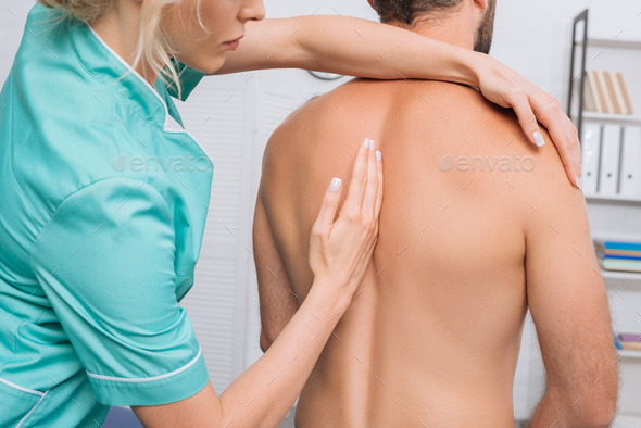 back view of man having chiropractic adjustment in clinic