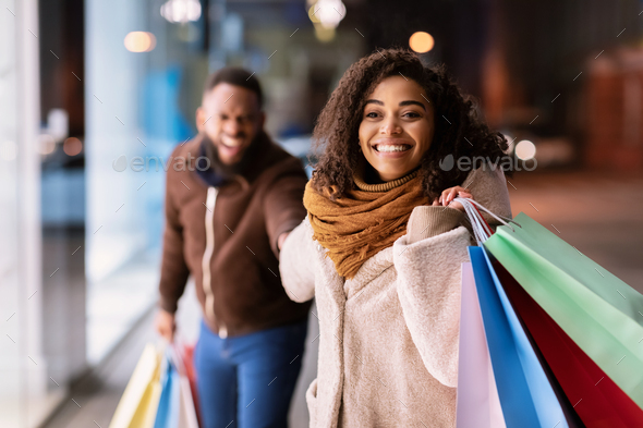 Excited Black Lady Pulling Boyfriend To Shopping Store