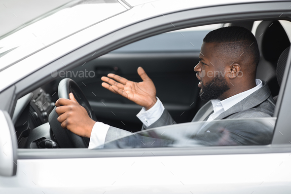 Furious black driver fighting on the road, stuck in traffic