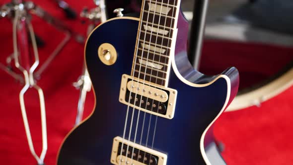 A vintage blue electric guitar on a concert stage in a rock and roll garage band setting. alt
