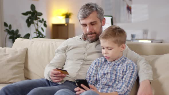 Man Teaching Son to Shop Online alt