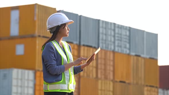 Worker woman checking and control loading containers box from cargo