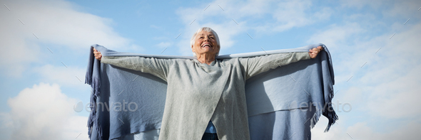 Composite image of happy elder woman raising her arms up