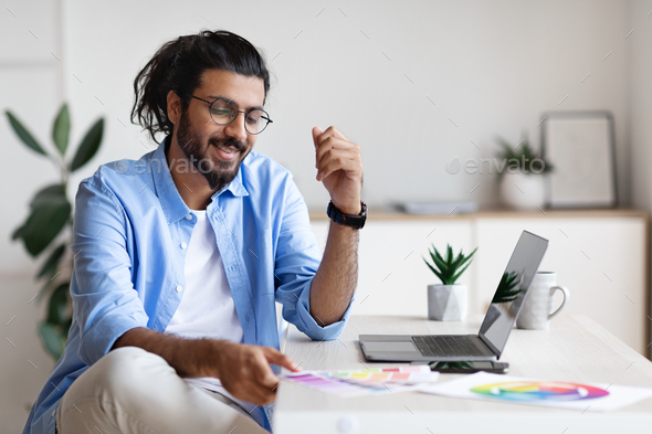 Indian Graphic Designer Working With Color Swatches And Laptop At Home  Office Stock Photo by Prostock-studio