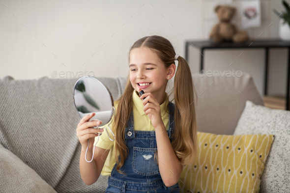 Young Girl Holding Lipstick, Looking At Mirror