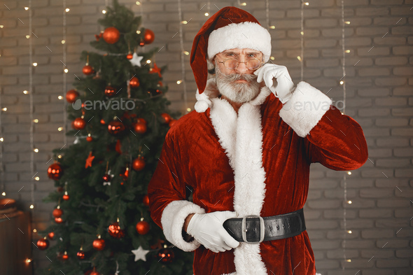 Man in santa claus costume looking at the camera - Stock Photo - Images