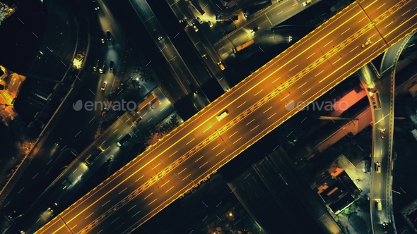 Top down of traffic road at night illuminate aerial. Metropolis cityscape with modern buildings