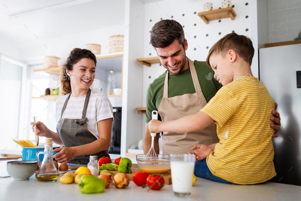 Happy family preparing healthy food together in kitchen Stock Photo by  nd3000