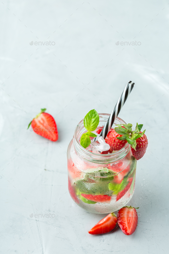 Mojito cocktail with white rum, soda, red strawberry and basil Stock