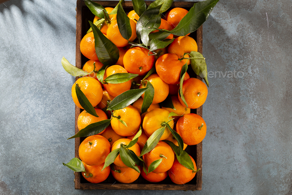 Fresh mandarin oranges fruit or tangerines with leaves in wooden box, top  view Stock Photo by GitaKulinica