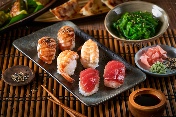 Sushi Set nigiri and sushi rolls on wooden serving board with soy sauce and  chopsticks over black stone texture background. Top view with space. Japan  menu Stock Photo