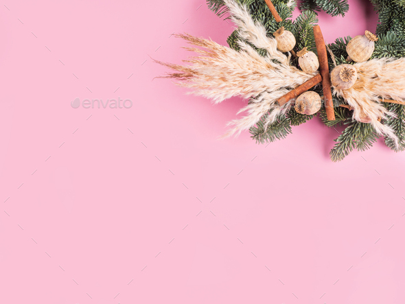 Christmas spruce wreath with dry decor on pink