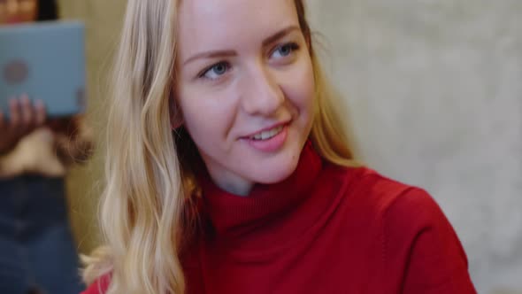 Young Female Architect Smiling and Chatting with Coworker