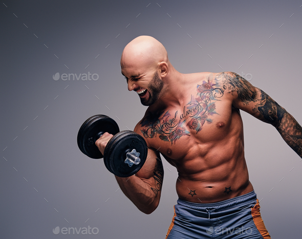 Side view of tranquil male with tattooed bald head standing with closed  eyes in nature against