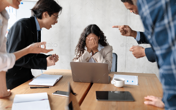 Aggressive Coworkers Yelling At Victimized Businesswoman Sitting In Modern Office