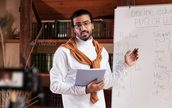 Teacher Teaching Online Standing Near Blackboard Explaining English Grammar Indoor