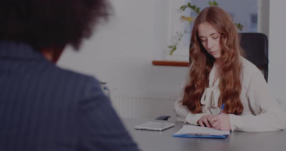 Businesswoman Signing Document in Office alt