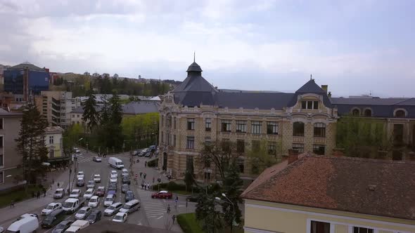 Aerial Tilting Shot of Downtown Cluj Napoca, Romania Revealing Traffic on the Roadway. alt