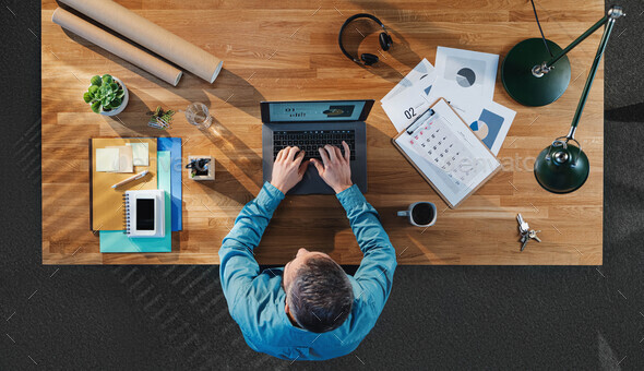 Businessman at the desk, office gadgets and supplies Stock Photo by  halfpoint