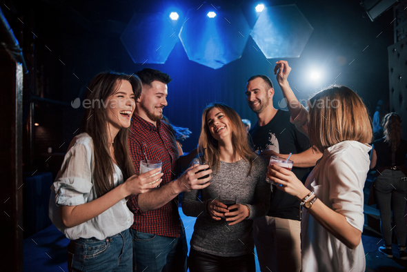 Girl is too shy to dance. Beautiful youth have party together with alcohol in the nightclub