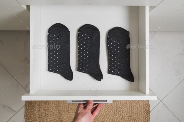 Drawer with three same male socks minimalism lifestyle concept. Top view