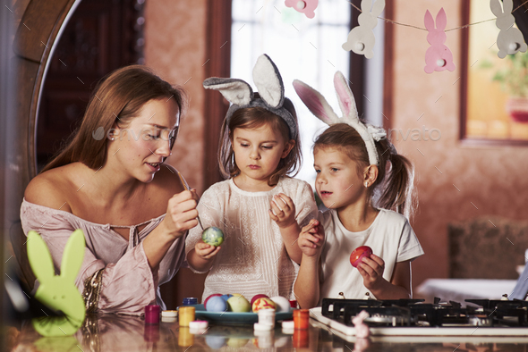 Have happy easter. Two little girls learning how to paint eggs for the holidays