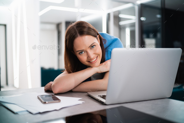 Portrait of happy successful caucasian woman in informal wear looking and smiling at the camera - Stock Photo - Images