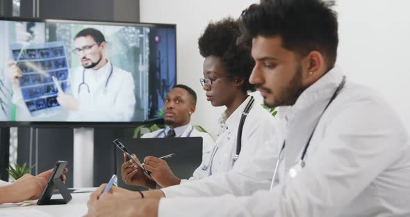 Mixed Race Medical Team which Listening Video Presentation on Digital Whiteboard in Office Room alt