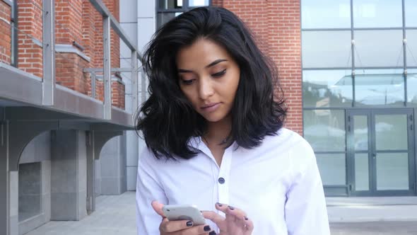 Girl Walking and Using Smartphone for Online Browsing alt