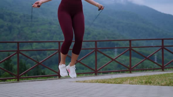 Sportive Woman is Training Alone Outdoors Skipping Rope alt