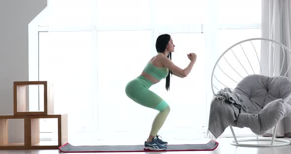 Fitness athlete performs exercises on the buttocks at home.