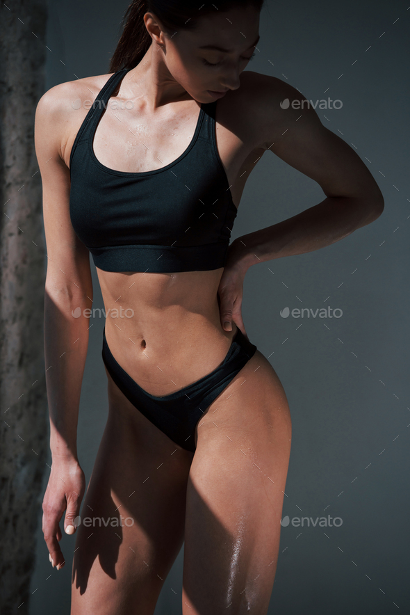 Tall fit girl. Caucasian pretty woman stands against wall in the studio at  daytime Stock Photo by mstandret