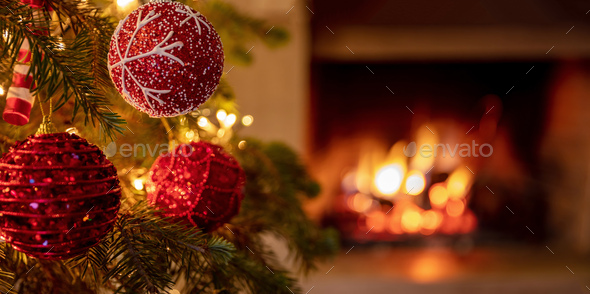 Christmas tree close up on blurred burning fireplace background Stock Photo  by rawf8
