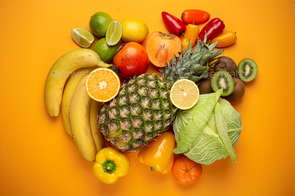 Fruit, citrus, vegetables with vitamin C, yellow orange background top view  Stock Photo by its_al_dente