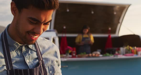 Young man looking at his phone by food truck alt