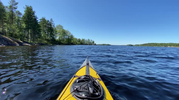 Sports Kayak Sails Along Tranquil Lake Water Past Island alt