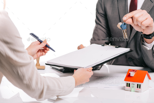 cropped view of mortgage broker and woman making deal and holding keys isolated on white, mortgage - Stock Photo - Images