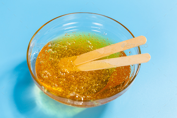 Depilation and beauty concept - close-up of sugar paste or honey wax for  hair removing spatula with Stock Photo by Satura_